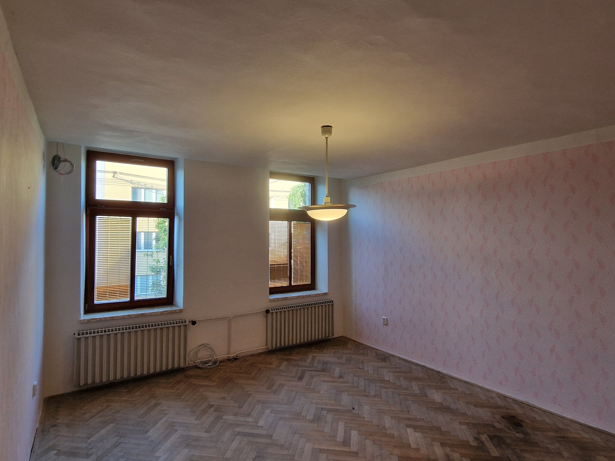 Ložnice se dvěma okny a parketovou podlahou